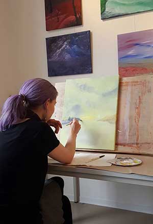 Lisa Stremlau malt bei einer Ausstellung